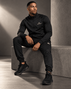 Airavon Seated model wearing a black tracksuit