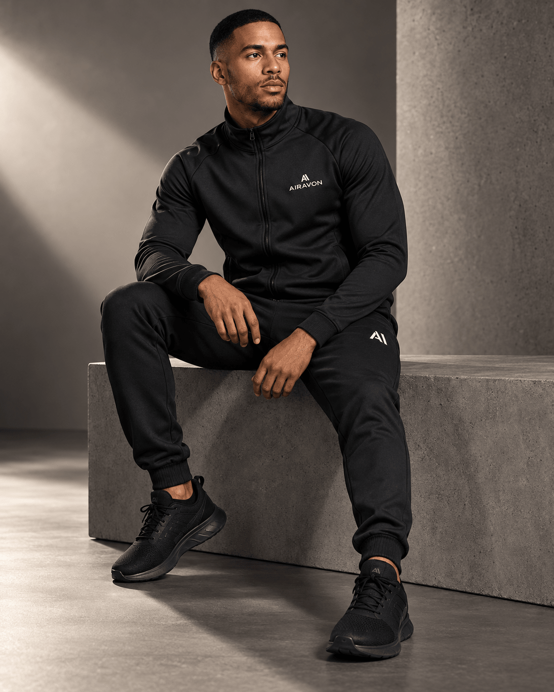 Airavon Seated model wearing a black tracksuit