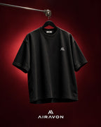 Airavon Black oversized T-shirt hanging against a red background